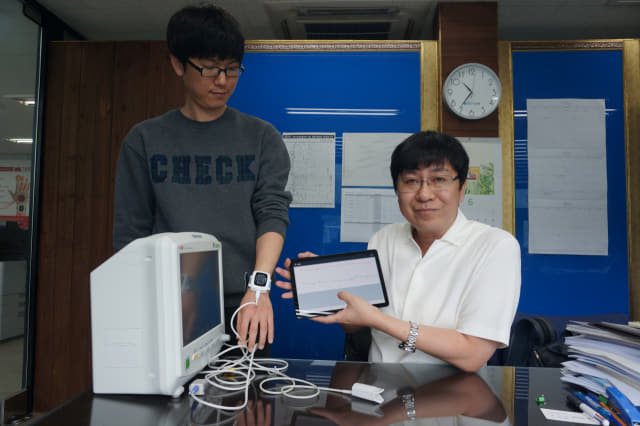 창원 엠텍글로벌㈜ 권수범(오른쪽) 대표이사와 직원이 지난 14일 웨어러블(Wearable) 산소포화도 측정기를 보여주고 있다. 왼쪽은 기존 산소포화도 측정기./창원 엠텍글로벌/