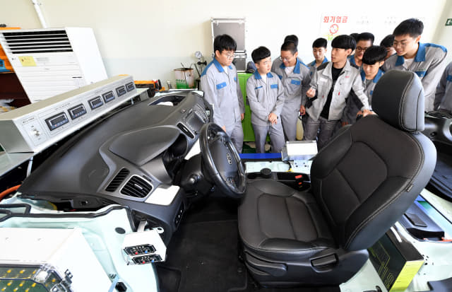 자동차과 2학년 학생들이 자동차엔진정비실에서 전기자동차 엔진정비 요령을 배우고 있다.
