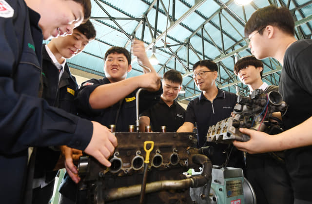 중기자동차시스템과 1학년 학생들이 자동차 엔진정비 실습을 하고 있다.