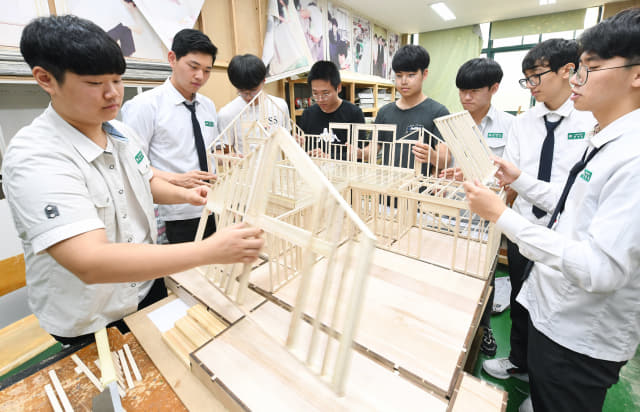 김해건설공고 건축디자인과 3학년 학생들이 직접 설계한 경량목공주택을 조립하고 있다.