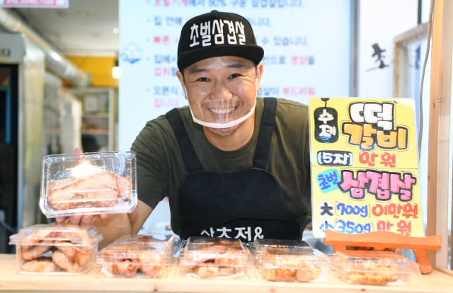 창원시 가음정시장에서 수제 떡갈비, 초벌 삼겹살을 판매하고 있는 박정호씨가 환하게 웃고 있다./김승권 기자/