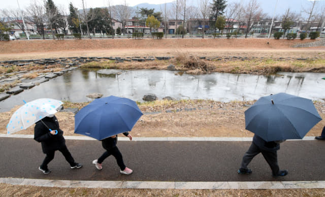 포근한 날씨 속에 겨울비가 내린 27일 오후 창원시 성산구 창원천 산책로에서 우산을 쓴 시민들이 산책을 즐기고 있다./성승건 기자/