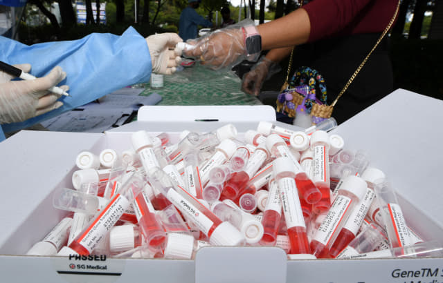 22일 오후 창원시 의창구 팔용미관광장에 마련된 외국인 주민을 위한 임시선별진료소에서 의료진이 코로나19 검사 키트를 나눠주고 있다./성승건 기자/