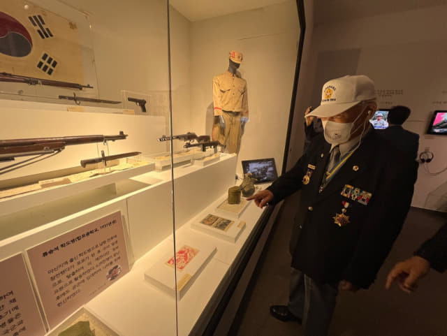 마산방어전투에 학도병으로 참전한 류승석씨가 전투 당시 쓰였던 장비들을 가리키고 있다.