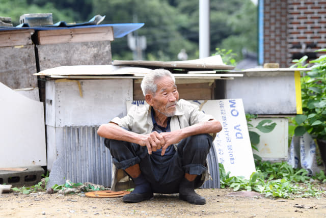 신판도(93)씨가 의령군 궁류면 입사마을에서 마당에 있는 토종벌통 앞에 앉아 있다.