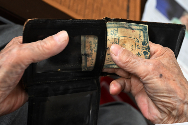 임채석 참전유공자가 제대증을 보여준 후 지갑에 넣고 있다.