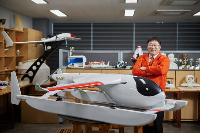 진주 ㈜엔젤럭스 김도현 대표가 도심 항공 모빌리티로 개발에 착수한 수륙양용 에어택시 모형 앞에서 활짝 웃고 있다.