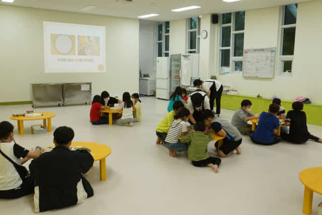김해 회현연가 치즈스토리 치즈·피자 체험관에서 아이들이 선생님과 함께 피자를 만들고 있다.