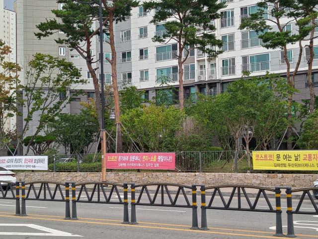 코스트코 김해점 인근 아파트단지 울타리에 설치된 항의 플래카드.