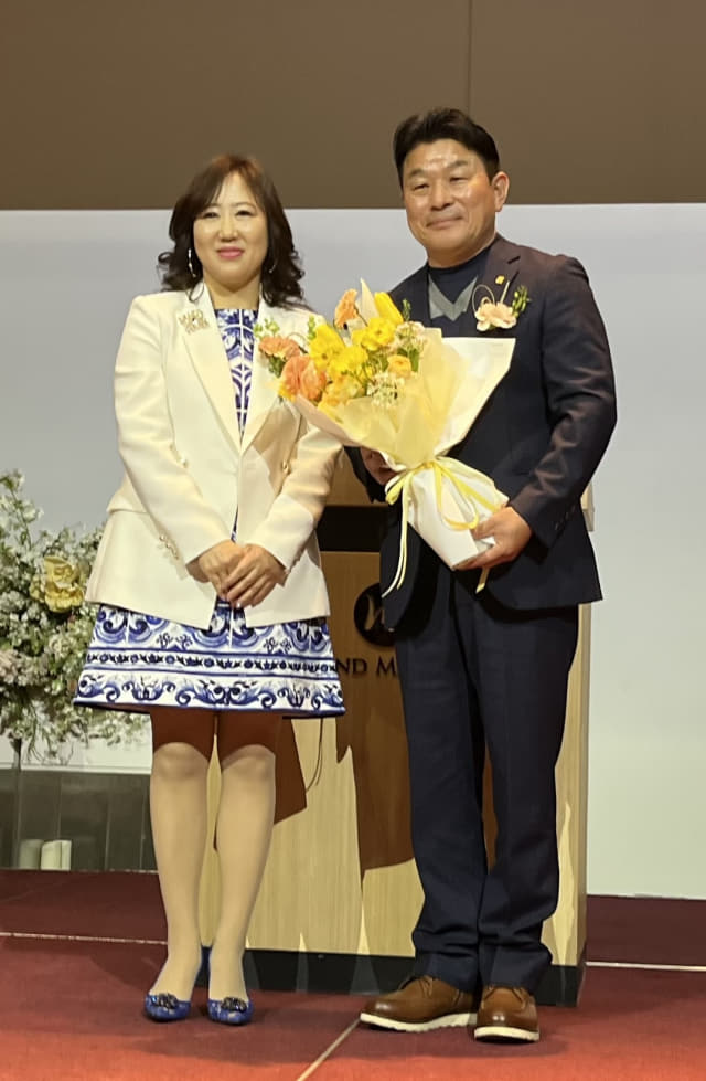 경남양궁협회 조은원(왼쪽) 회장이 이현화 전임 회장에게 꽃다발을 전달한 후 기념사진을 찍고 있다./권태영 기자/